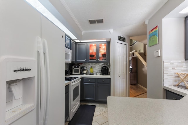 kitchen featuring white appliances, tasteful backsplash, ornamental molding, and light tile patterned floors