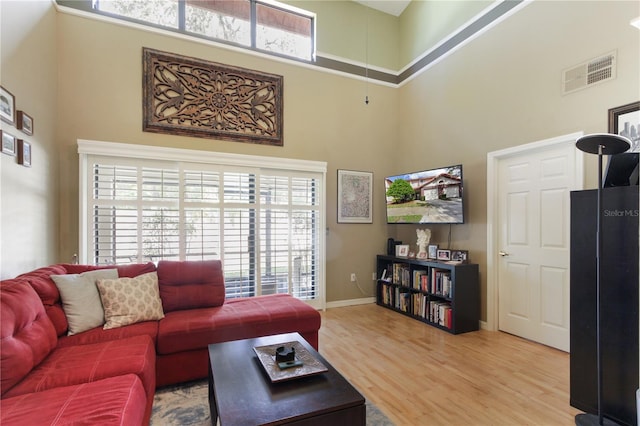 living room featuring a high ceiling and light wood-type flooring