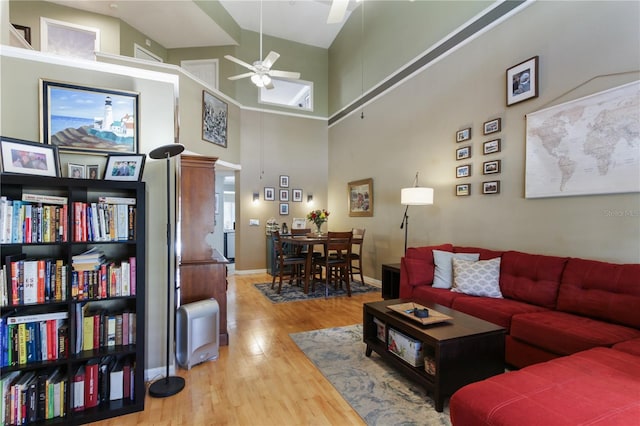 living room with hardwood / wood-style floors, high vaulted ceiling, and ceiling fan