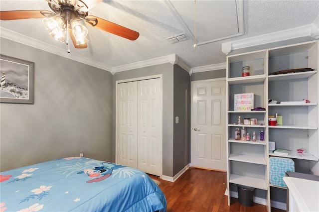 bedroom featuring a textured ceiling, a closet, ceiling fan, dark wood-type flooring, and crown molding