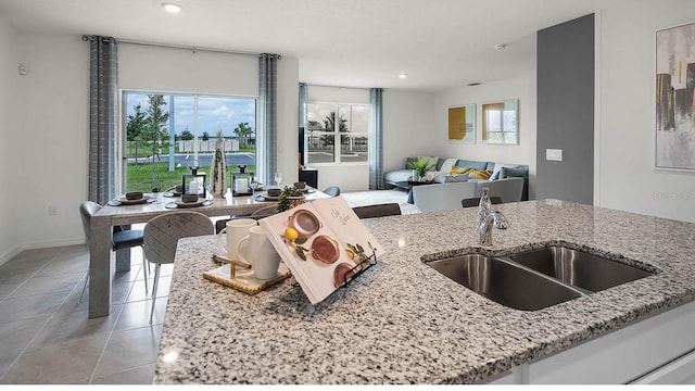 kitchen with light stone countertops, sink, and light tile patterned floors