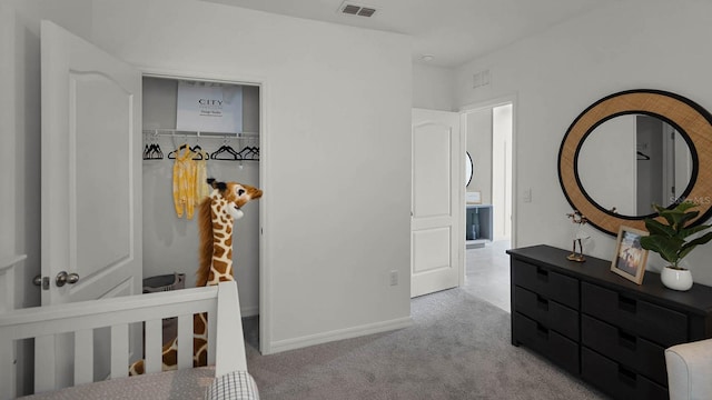 bedroom with light colored carpet, a closet, and a crib