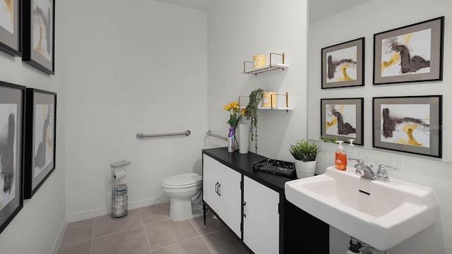 bathroom with toilet, sink, and tile patterned flooring