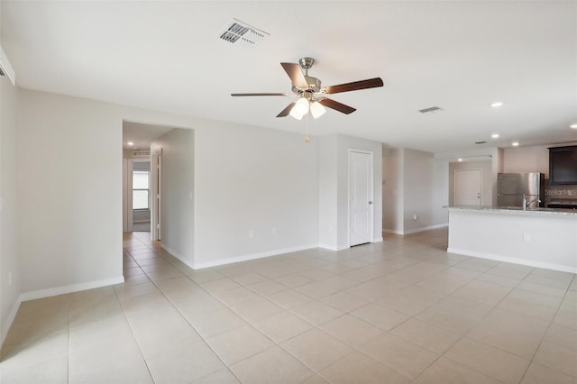 tiled spare room featuring ceiling fan