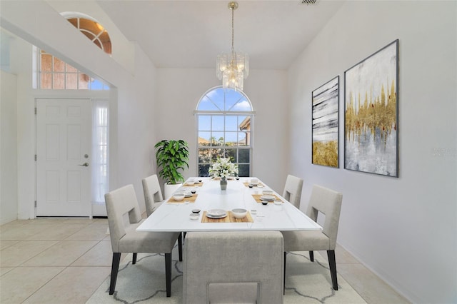 tiled dining space featuring an inviting chandelier