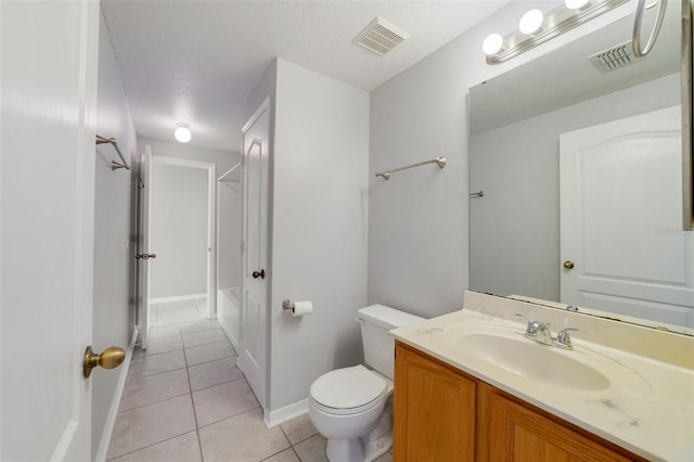 bathroom with toilet, vanity, a textured ceiling, and tile patterned floors