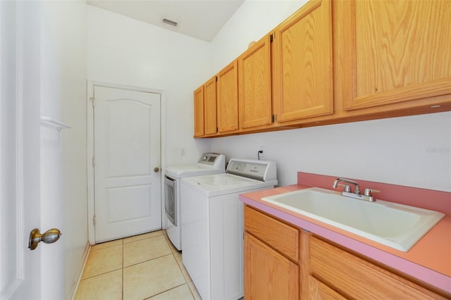 laundry area with independent washer and dryer, cabinets, sink, and light tile patterned flooring