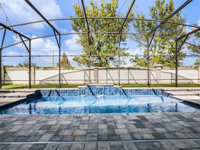 view of pool with a patio, pool water feature, and a lanai