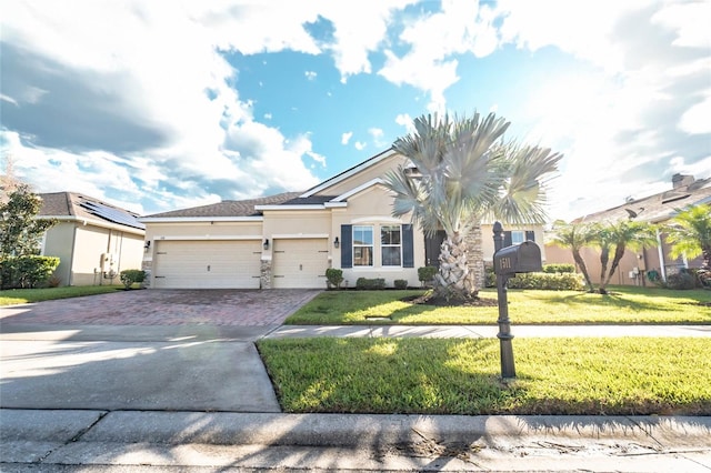 view of front of property featuring a front lawn and a garage