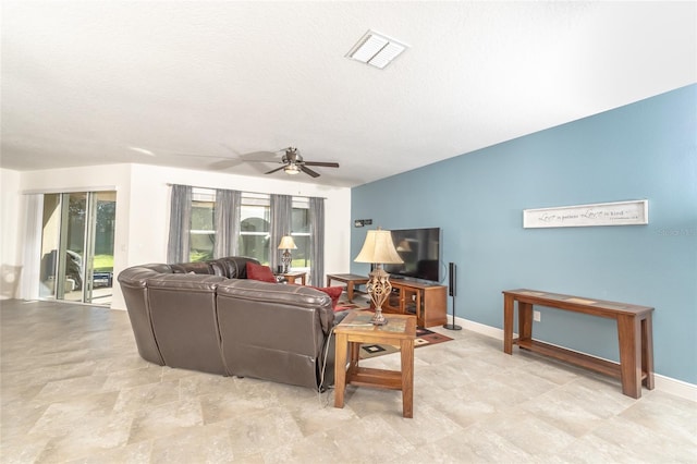 living room featuring ceiling fan and a textured ceiling