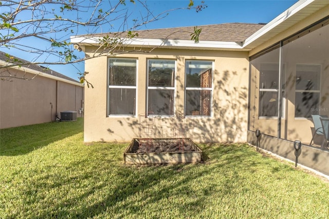 rear view of house featuring cooling unit and a yard