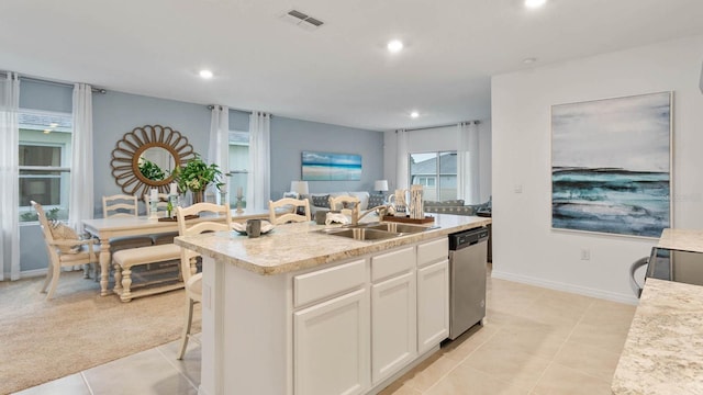 kitchen with sink, an island with sink, white cabinetry, stainless steel appliances, and light tile patterned floors