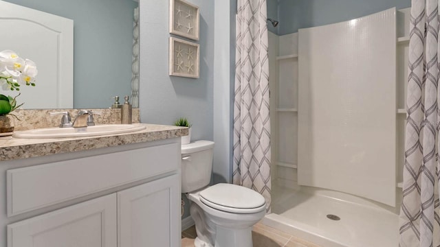 bathroom with toilet, curtained shower, vanity, and tile patterned floors