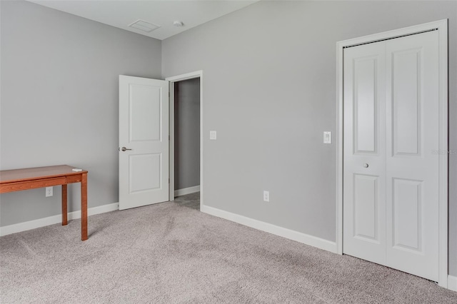 unfurnished bedroom with light carpet and a closet