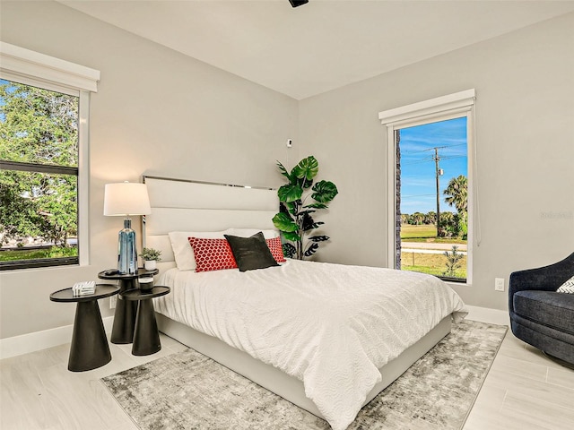 bedroom with light hardwood / wood-style flooring and multiple windows