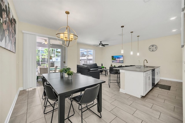 dining room with sink and ceiling fan with notable chandelier