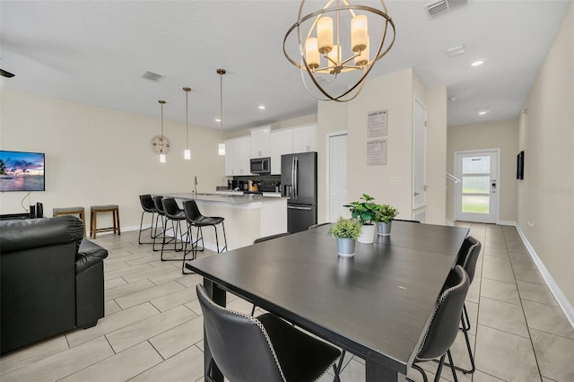 dining space featuring light tile patterned flooring and an inviting chandelier