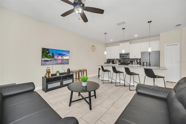 living room with ceiling fan and sink