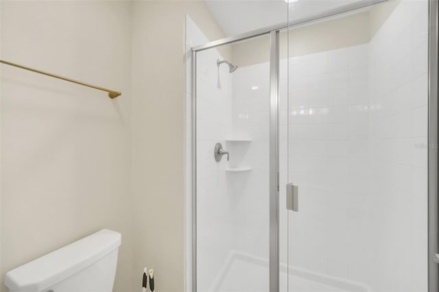 bathroom with toilet and a shower with shower door