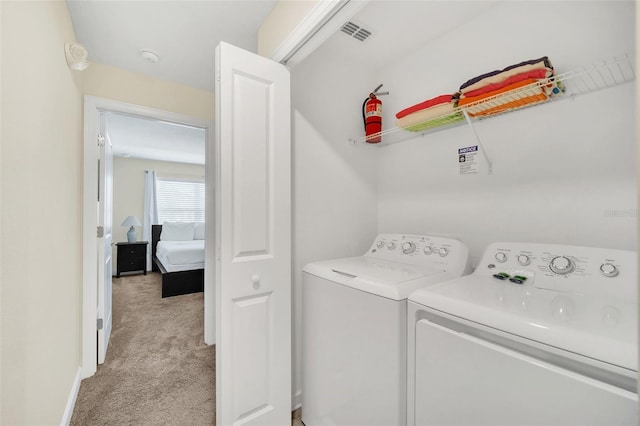 laundry area featuring light carpet and washing machine and clothes dryer