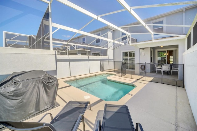 view of pool with grilling area, a patio, and glass enclosure