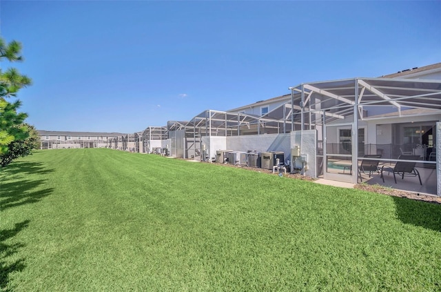 view of yard featuring a patio area, a lanai, and central AC unit