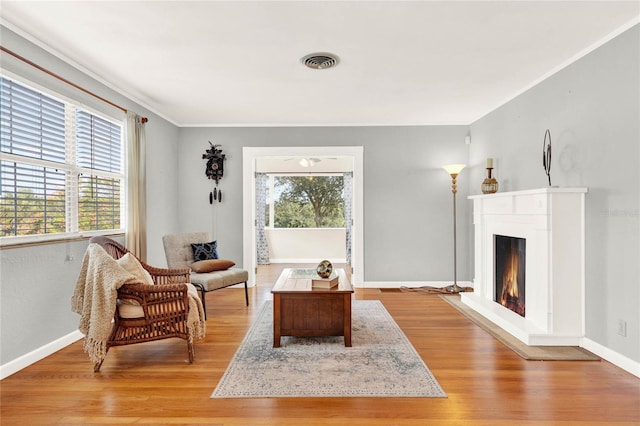 sitting room featuring ornamental molding and light hardwood / wood-style flooring