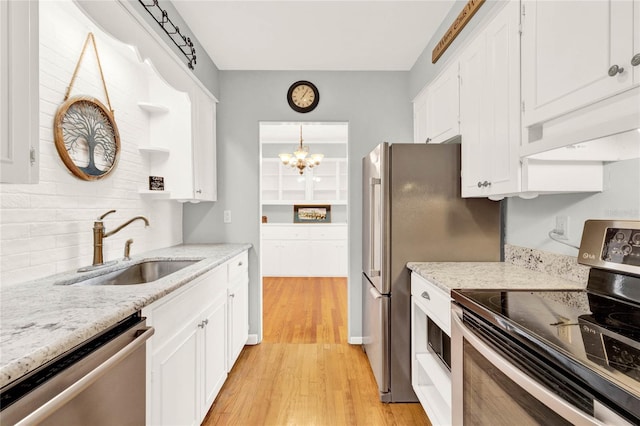 kitchen featuring sink, decorative light fixtures, light hardwood / wood-style floors, white cabinetry, and stainless steel appliances