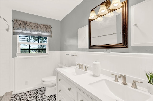 504 Osceola Ave, Eustis, FL 32726 - bathroom featuring toilet, a wainscoted wall, double vanity, a shower, and tile patterned floors