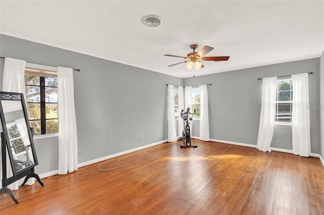 unfurnished room with hardwood / wood-style floors, plenty of natural light, and ceiling fan