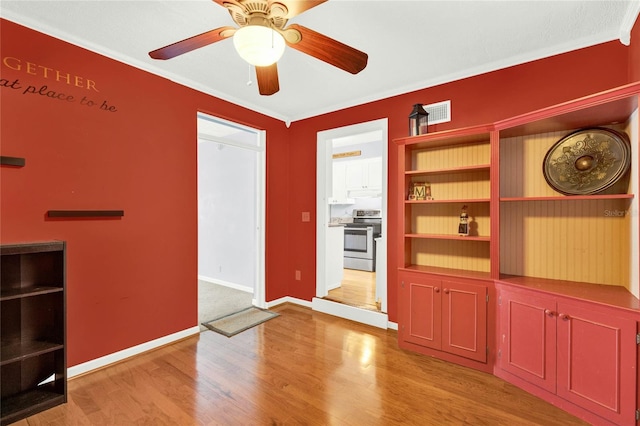 interior space featuring light wood-type flooring, ceiling fan, and crown molding