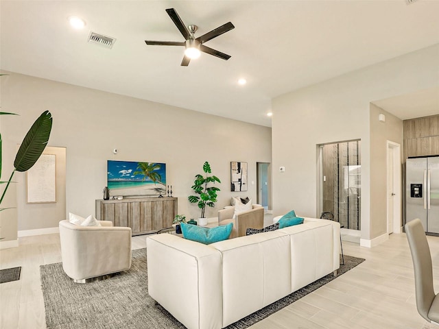 living room with light hardwood / wood-style flooring and ceiling fan