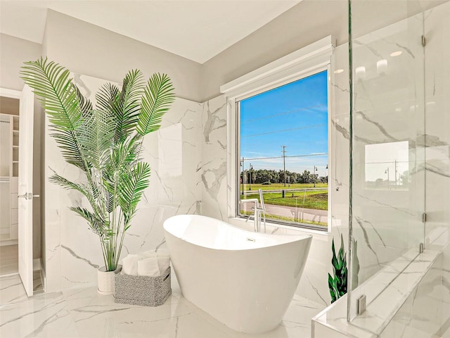 bathroom featuring shower with separate bathtub and tile walls