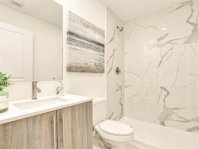 bathroom featuring vanity, toilet, and tiled shower