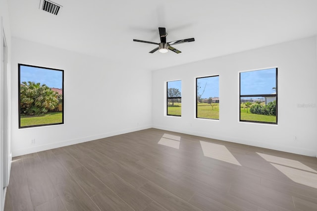 spare room featuring ceiling fan, plenty of natural light, and light hardwood / wood-style flooring