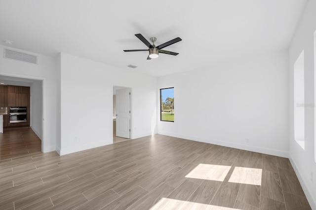 empty room with ceiling fan and light wood-type flooring