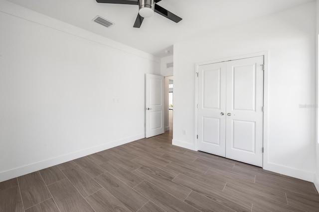 unfurnished bedroom with ceiling fan and a closet