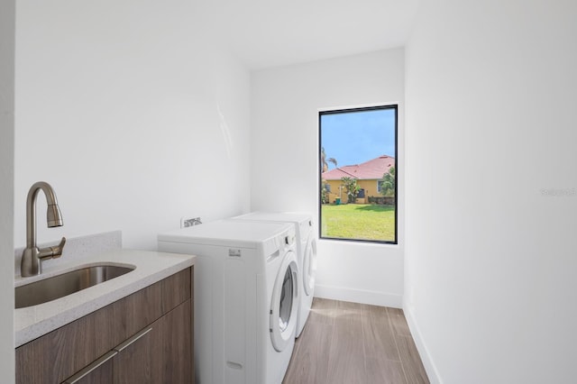 washroom with sink, cabinets, and independent washer and dryer