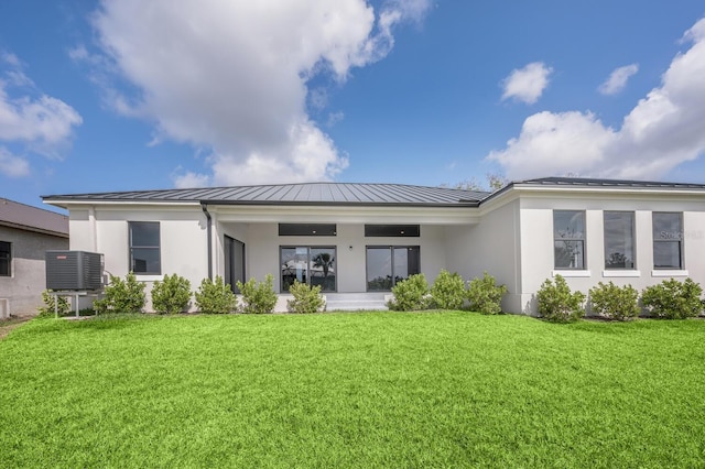 back of property with a yard and central air condition unit