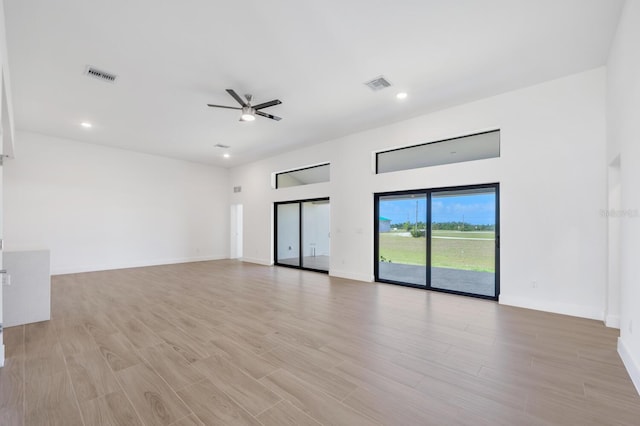 unfurnished living room featuring ceiling fan and light wood-type flooring