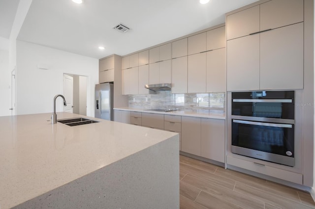 kitchen featuring stainless steel appliances, tasteful backsplash, and sink