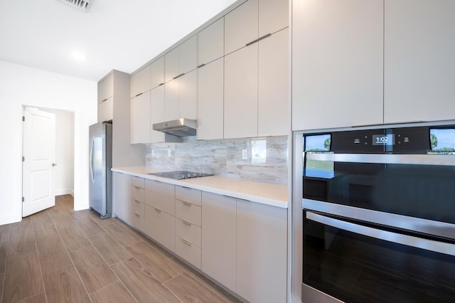 kitchen with appliances with stainless steel finishes and backsplash