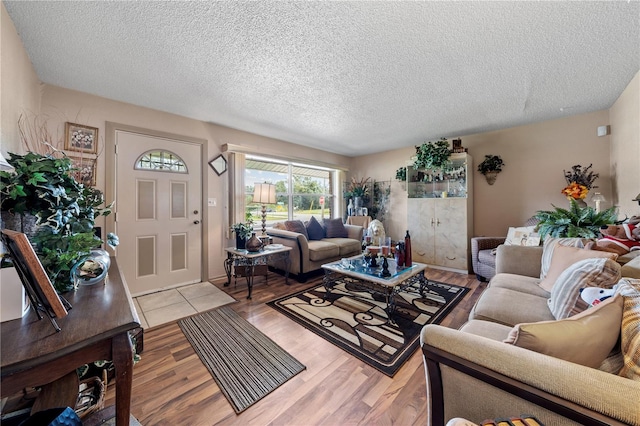 living room with a textured ceiling and light hardwood / wood-style floors