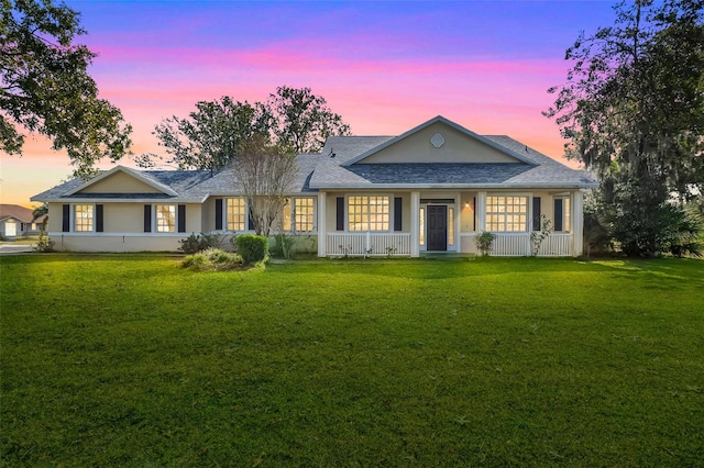 single story home with a porch and a yard