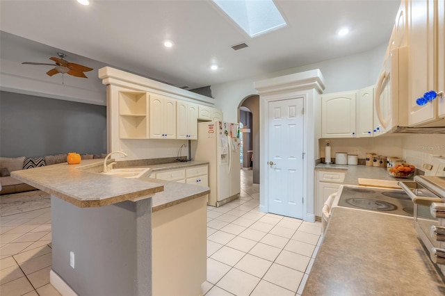 kitchen featuring white appliances, sink, kitchen peninsula, ceiling fan, and a breakfast bar area