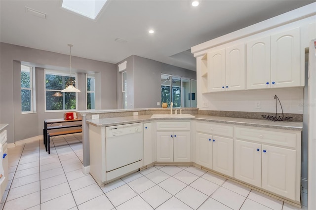 kitchen with dishwasher, kitchen peninsula, sink, decorative light fixtures, and a skylight