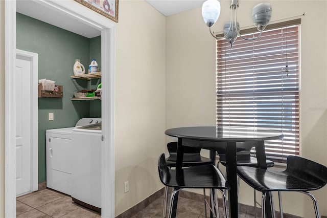 laundry area with a notable chandelier, separate washer and dryer, and light tile patterned floors