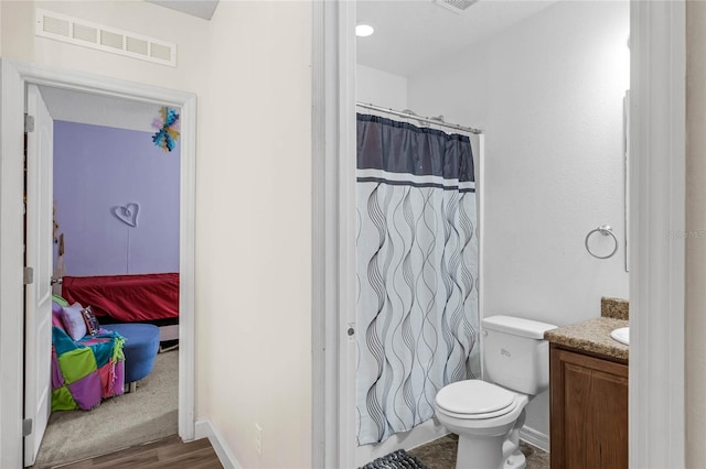 bathroom with vanity, hardwood / wood-style flooring, and toilet