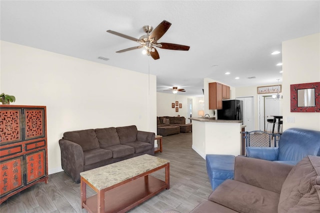 living room with ceiling fan and light wood-type flooring