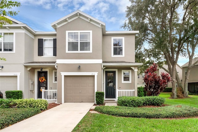 townhome / multi-family property featuring covered porch, a front lawn, and a garage